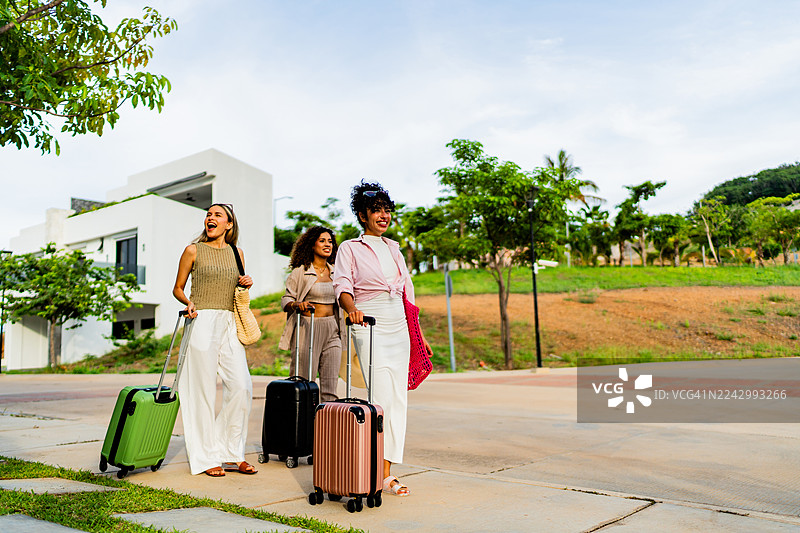 年轻的朋友们，女士们，抵达度假租赁房图片素材