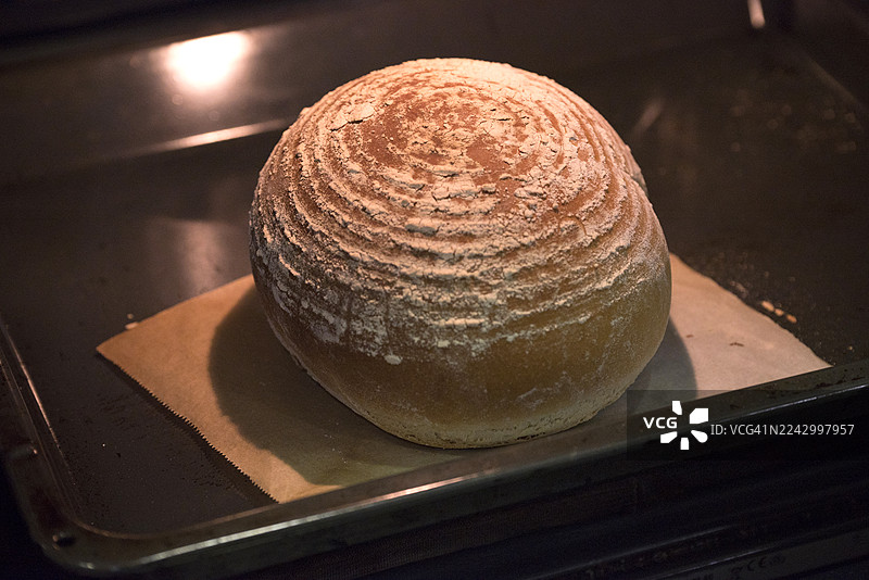 烤箱里正在烘烤的圆形自制面包图片素材