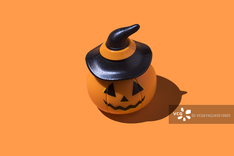 橙色背景上的万圣节南瓜灯。万圣节庆典概念，亡灵节，逝者与圣徒，恐怖，恐惧图片素材