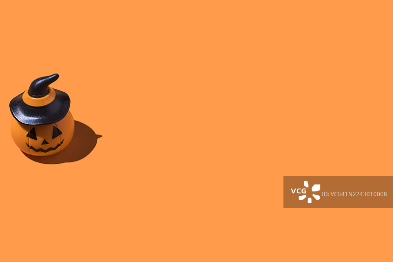橙色背景上的万圣节南瓜灯。万圣节庆祝概念，亡灵节，逝者与圣徒，恐怖，恐惧图片素材