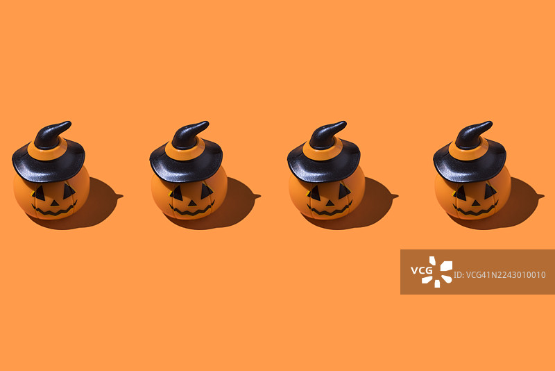 南瓜灯图案，一排排，橙色背景。万圣节庆典概念，亡灵节，亡者与圣徒，恐怖，恐惧图片素材