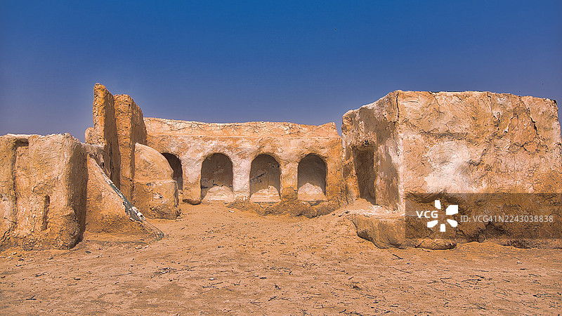 晴朗的蓝天下，古老的沙漠遗迹，散发着历史与荒凉的气息，突尼斯图片素材