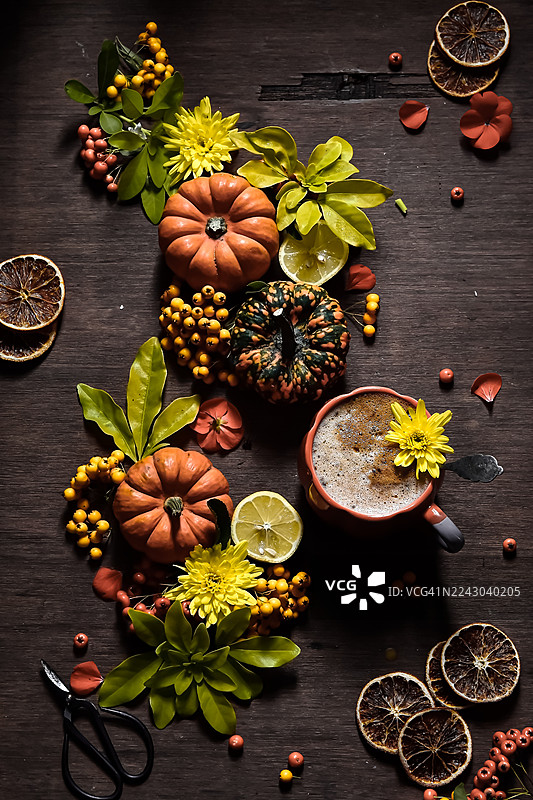 秋季静物，摆放着南瓜、浆果、鲜花和咖啡，置于乡村风格的木桌上，非常适合秋季主题概念。图片素材