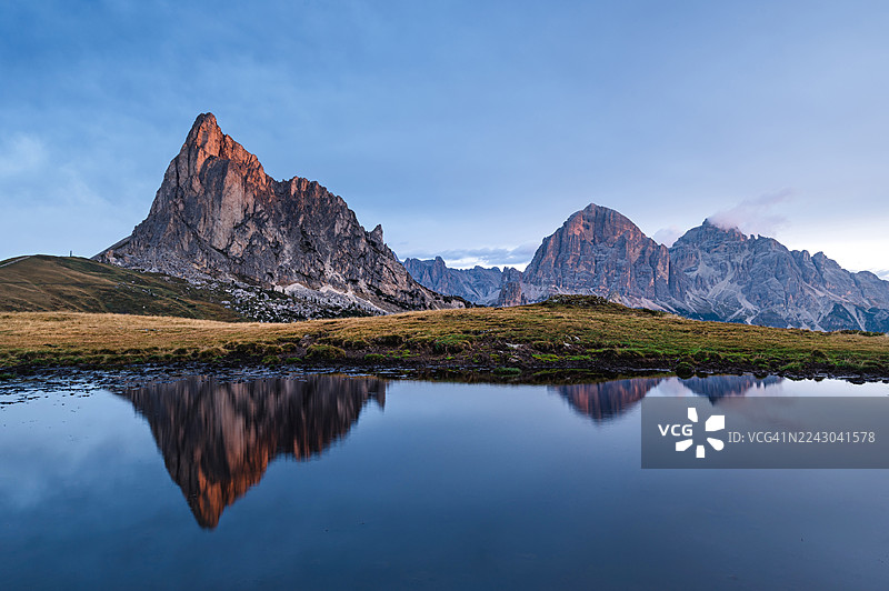 黎明时分，在湛蓝晴朗的天空下，雄伟的山峦倒映在宁静的湖水中，科莱圣卢西亚，意大利，贾乌山口图片素材