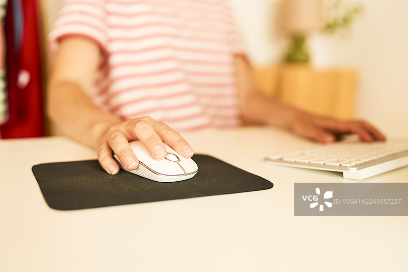 女性在家办公，使用电脑鼠标图片素材