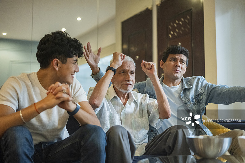 一家人其乐融融地观看足球比赛，在家中为他们最喜欢的球队加油助威，共享美好时光。图片素材