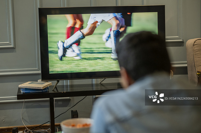 一家人一起享受足球比赛，共度美好时光，在家为他们最喜欢的球队加油助威图片素材
