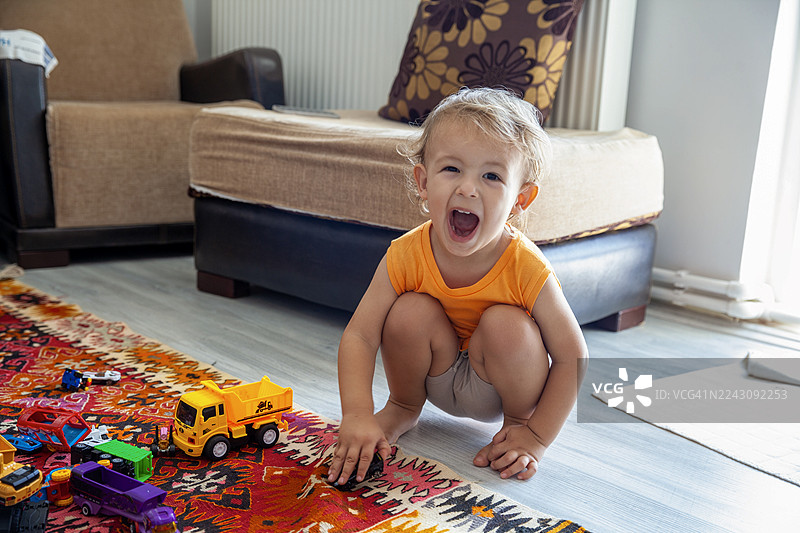 男孩张着嘴玩他的玩具图片素材