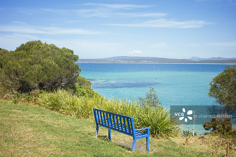 蓝色的空长椅，背景是海景图片素材