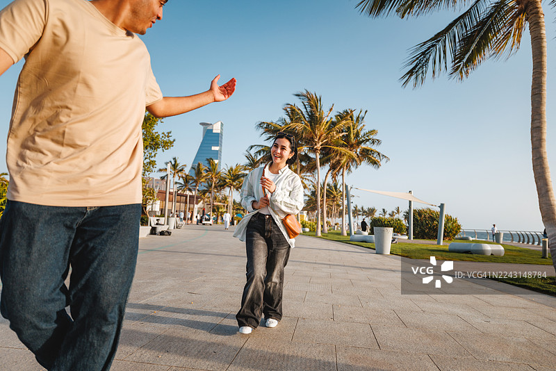 一对快乐的情侣在吉达海滨长廊上漫步图片素材