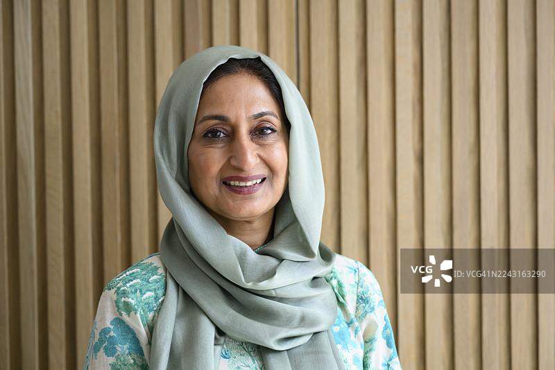 戴着头巾的快乐中年英裔亚洲女性肖像图片素材