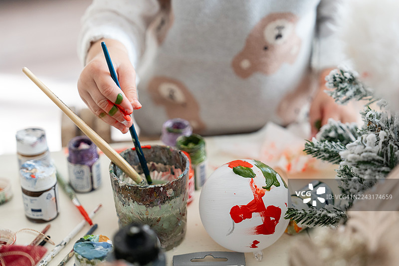 在冬季假期期间，特写镜头展示了手绘手工制作的圣诞树装饰品。图片素材