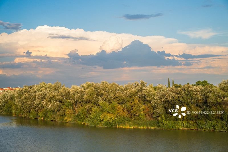 平静的河流与植物，背景有云彩图片素材