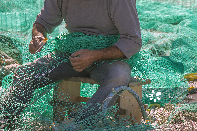 渔民在码头修补渔网图片素材