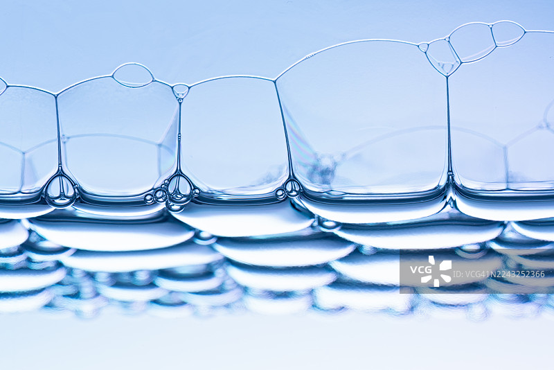 蓝色肥皂泡在水面上漂浮的特写视图图片素材