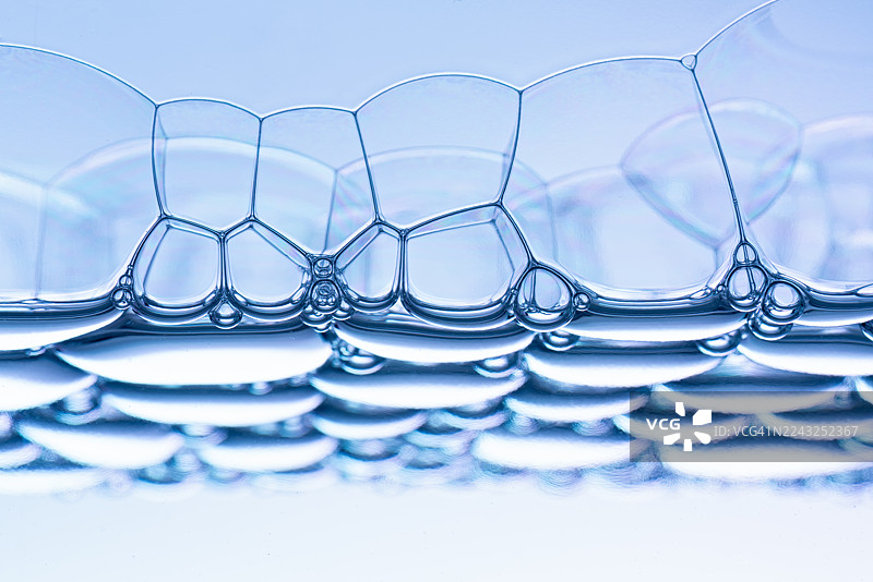 蓝色肥皂泡在水面上漂浮的特写视图图片素材