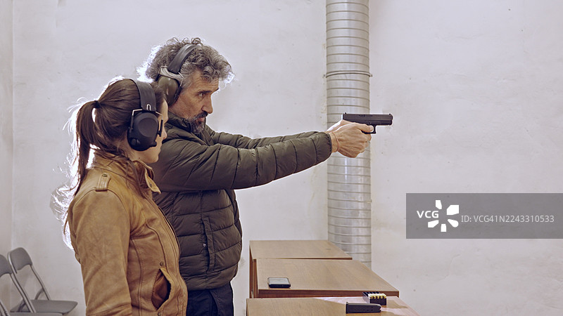 教官指导女性射击手枪，为防御而射击武器图片素材