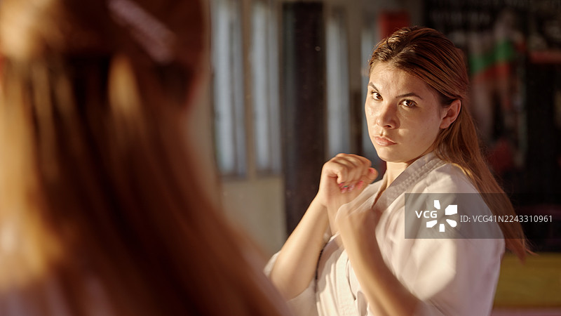 空手道训练。身穿和服的少年在镜子前练习格斗运动图片素材