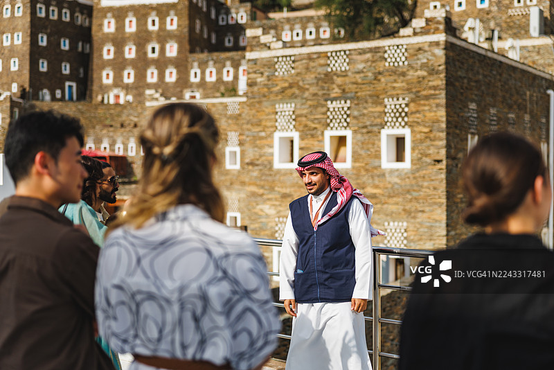 微笑的导游在历史遗迹处热情地为游客讲解图片素材
