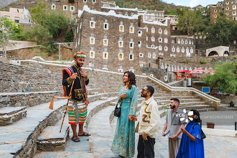 参观者与身着传统阿西尔服饰的导游交谈图片素材