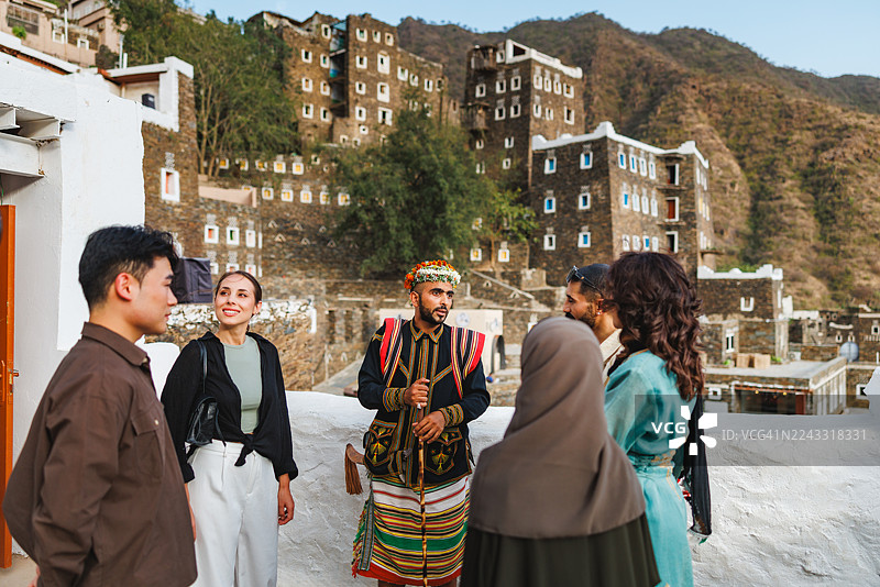 好奇的游客在历史遗迹处与沙特导游交谈图片素材