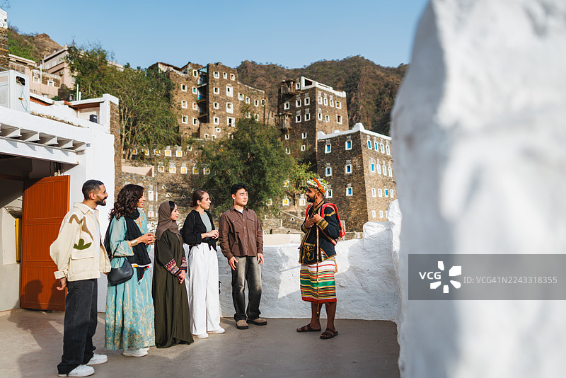热情好客的沙特向导在遗产村向游客展示风情图片素材