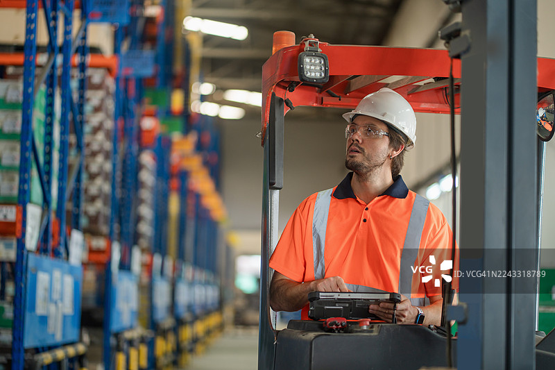 仓库操作员使用数字平板电脑进行自动化库存控制。图片素材