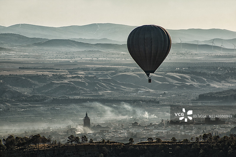 日出时分，热气球剪影掠过瓜迪克斯市，背景是宏伟的大教堂图片素材