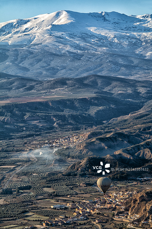 热气球飞越瓜迪克斯，背景是白雪皑皑的内华达山脉图片素材