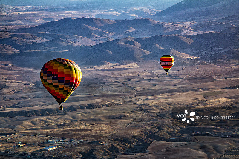 两只热气球在西班牙安达卢西亚瓜迪克斯的喀斯特地貌上空飞行图片素材