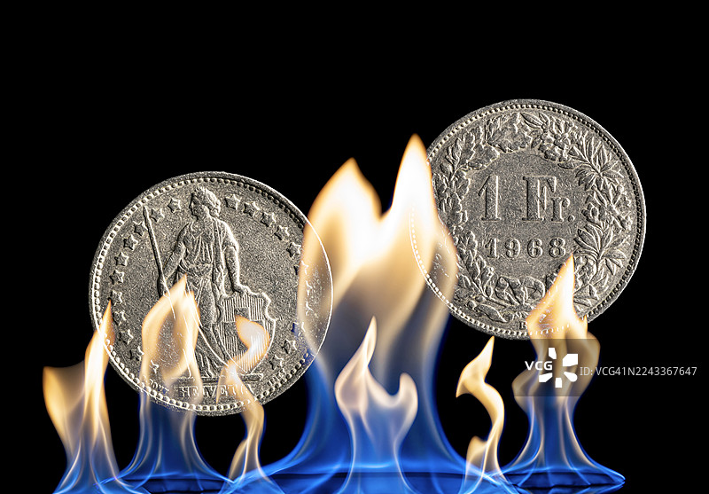 因经济过热而着火的一法郎硬币图片素材