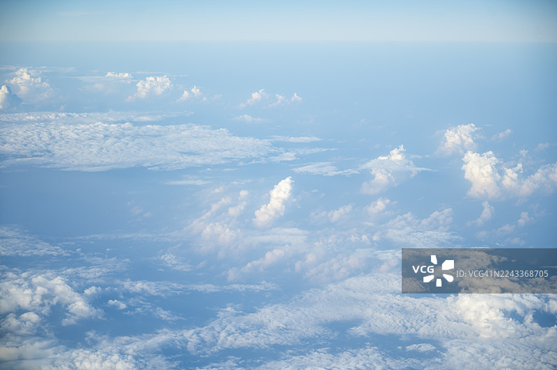 薄雾笼罩的山景之上，宁静的晨曦天空与柔和的云彩图片素材