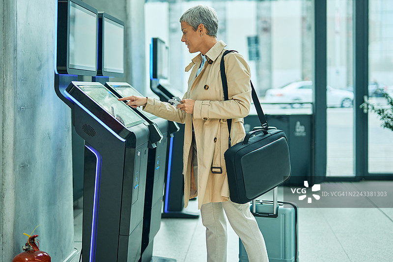成熟的成年女性使用自助值机亭图片素材