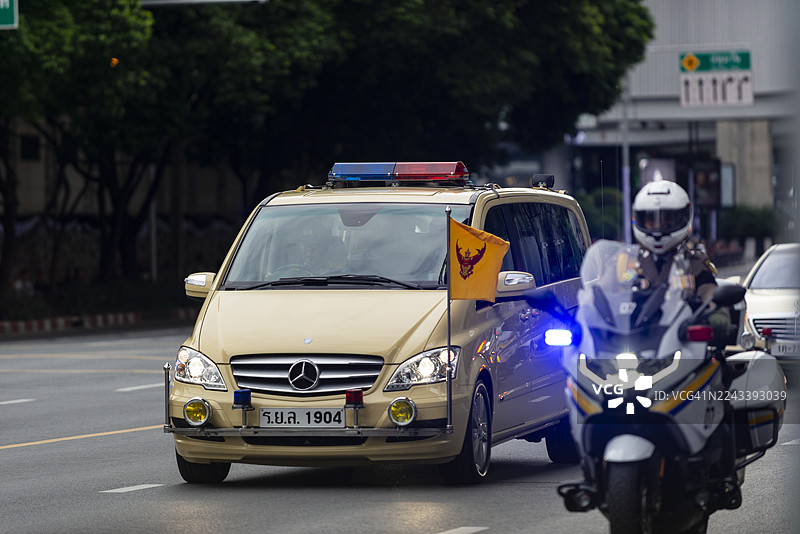 一辆装饰有皇家旗帜的货车，载着泰国王和王后，在诗丽吉王后仪仗队的后面庄重行进，地点为泰国曼谷。图片素材
