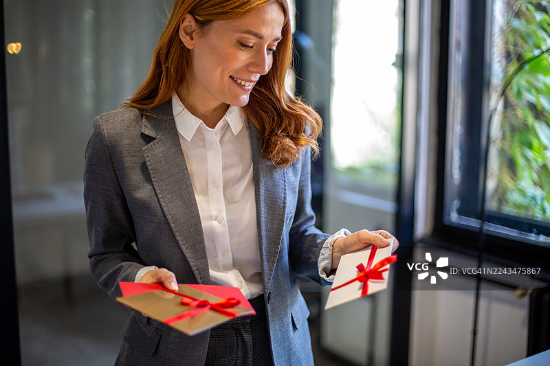 女商人手持礼品卡准备办公室庆祝活动图片素材