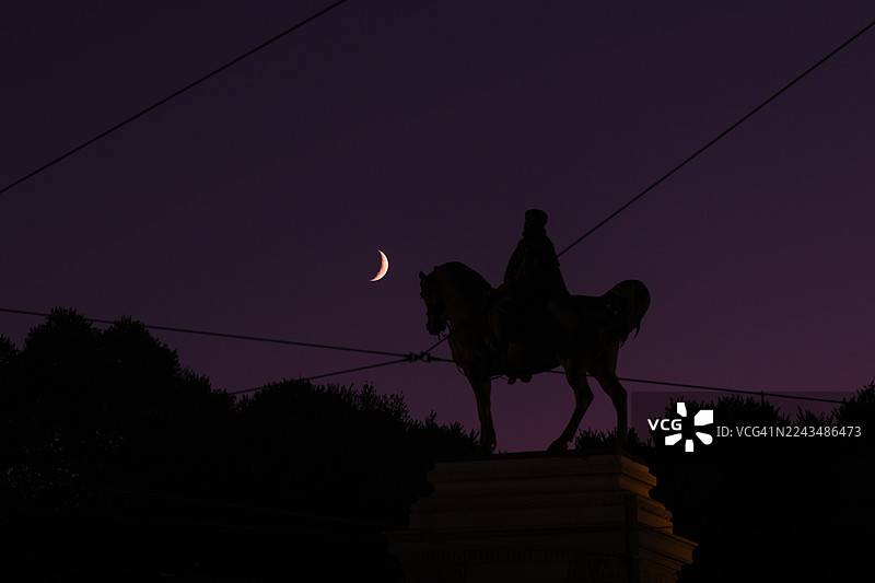 米兰朱塞佩·加里波第骑马雕像，新月下的剪影，紫色之夜的神秘图片素材