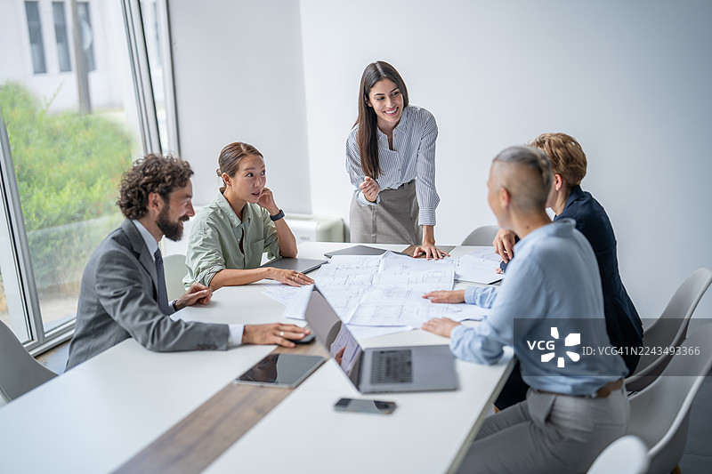 建筑师和工程师在现代办公室讨论计划图片素材