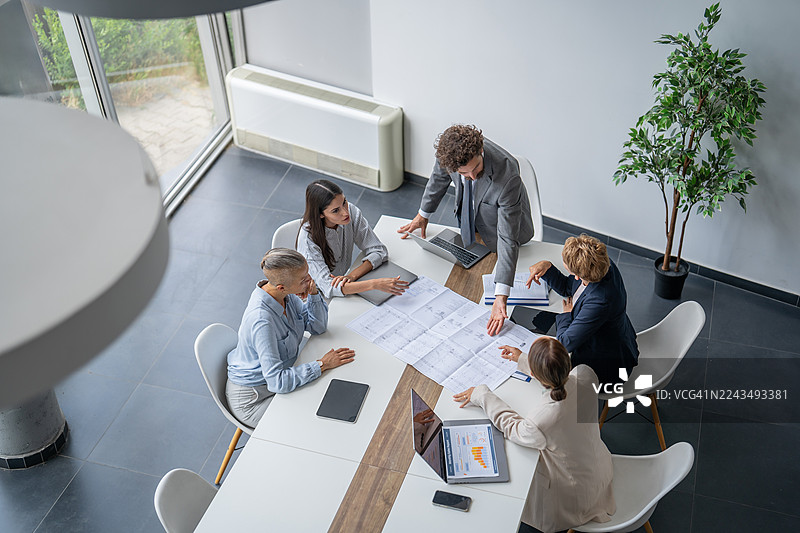 商务团队在现代办公室开会时分析蓝图图片素材