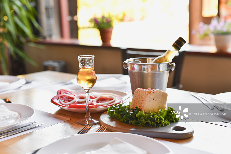 精致餐桌布置，配有白奶酪、番茄、拉克亚酒和冰桶，适合高档餐饮图片素材