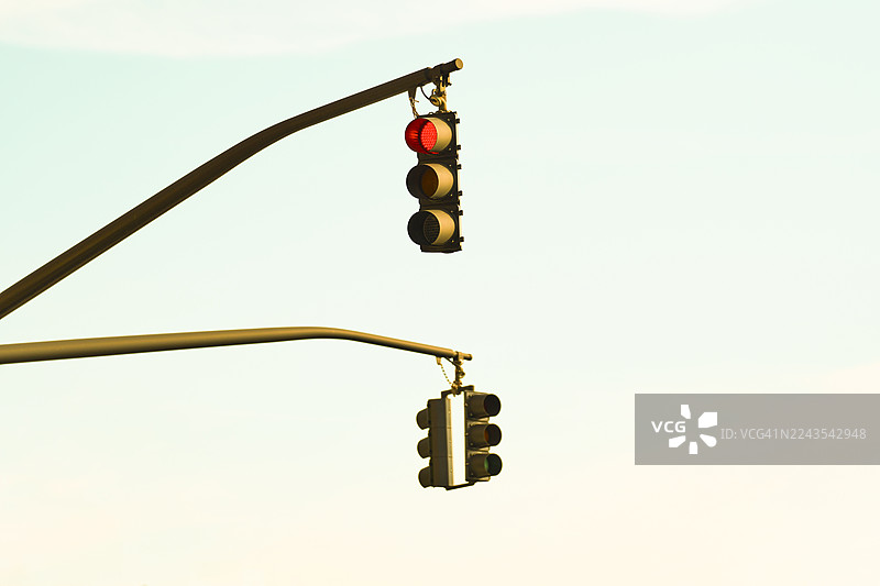 红灯交通信号在晴朗的天空下亮起图片素材