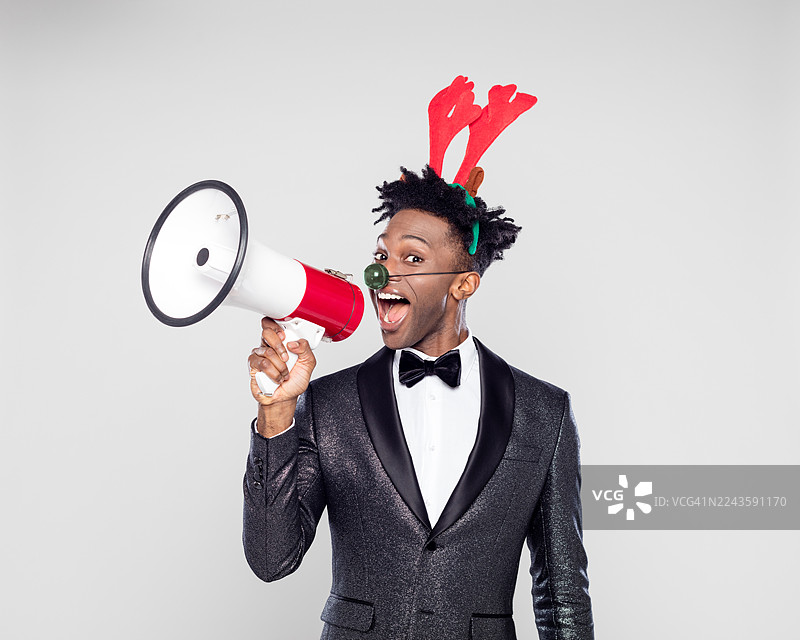 圣诞肖像，一位快乐优雅的男士，戴着驯鹿头饰，手持扩音器图片素材