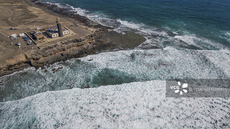 从空中俯瞰，位于延达半岛南端的法罗蓬塔德延达灯塔，前景是翻滚海浪卷起的白色浪花，礁石边缘有巨大的高浪，海面波涛汹涌，富埃特文图拉岛，加那利群岛，加那利群岛，西班牙图片素材