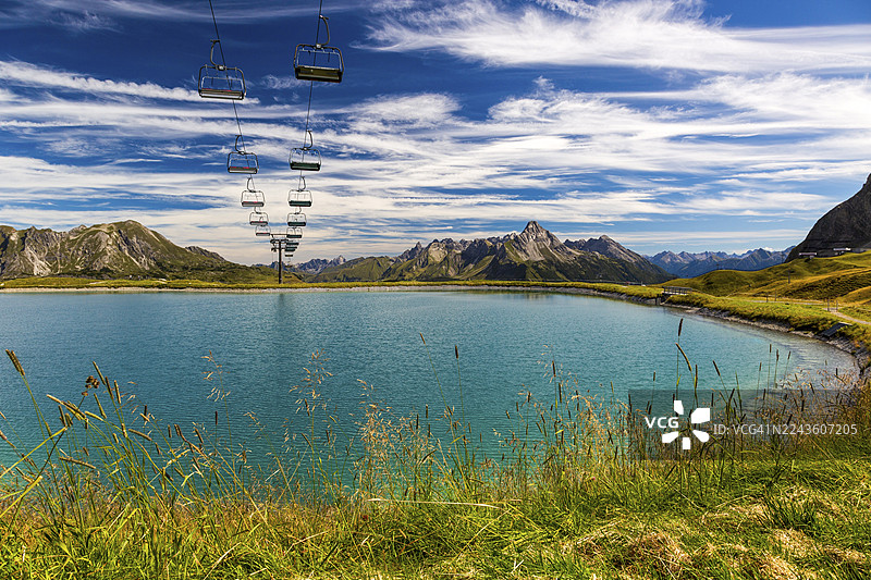 萨尔贝科夫的全景湖，背景有缆车和山脉，在蓝天下，瓦特，布雷根茨，福拉尔贝格，奥地利图片素材