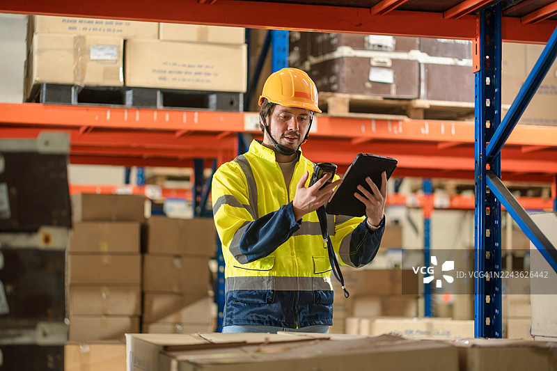 仓库工作人员使用条形码扫描器和 seus　平板电脑扫描货架布局。图片素材