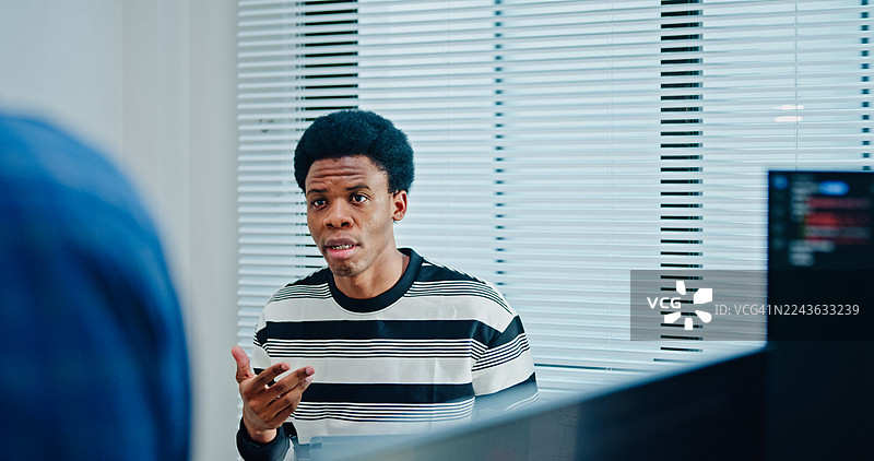 特写镜头：男性软件开发者在办公室的办公桌旁，使用数字平板电脑讨论项目编码。人工智能与编程概念。图片素材