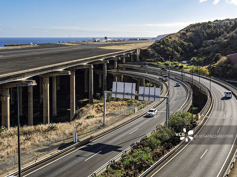 马德拉岛上，机场跑道下方横跨着一条有车辆行驶的高速公路。图片素材