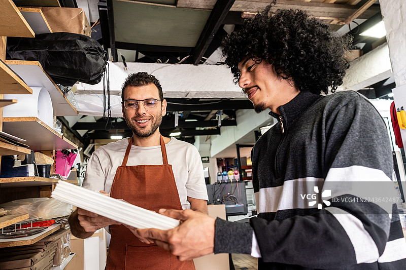 在数码印刷车间，同事们正在挑选纸张样品图片素材