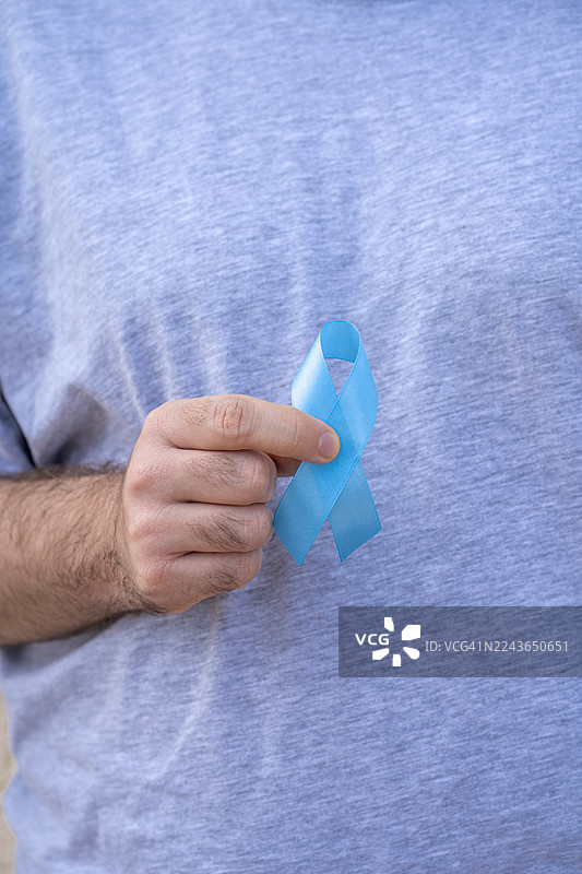 手持蓝色丝带，十一月图片素材