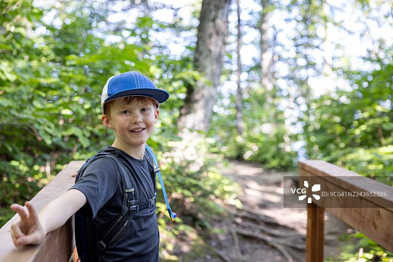 年轻的红发男孩沿着圣劳伦斯湾南岸徒步，位于加拿大魁北克省 Bic 国家公园（Parc National du Bic）图片素材