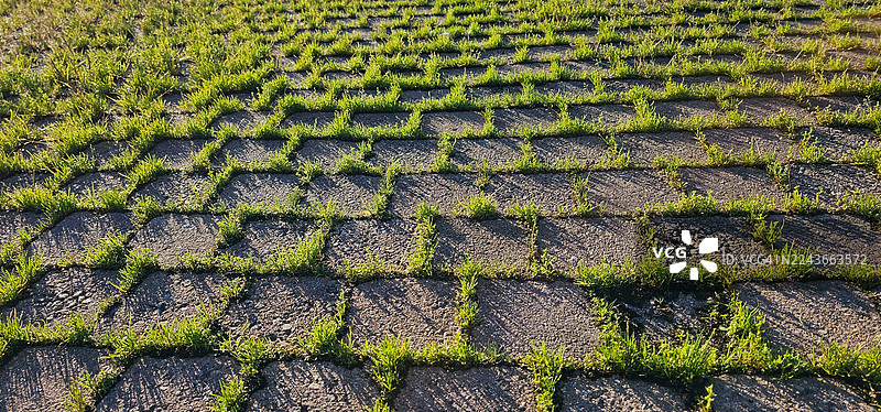 长满青草的废弃户外停车场。图片素材